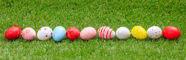 Easter concept. Colorful eggs on green grass, banner, copy space