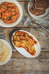 Meat deep-fried and a salad of eggplant and tomato serving on a table - a meal