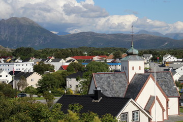 Fototapeta na wymiar typische Häuser und Kirche in Norwegen vor den Bergen in Molde