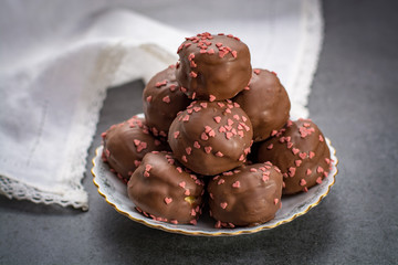 Valentine's Day concept, chocolate profiteroles with pink hearts, stuffed cakes,  special romantic event.