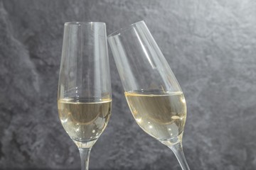 Zwei mit Champagner gefüllte Gläser vor grauem Hintergrund