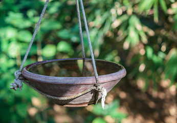 Birdbath hanging with the help of ropes in a park