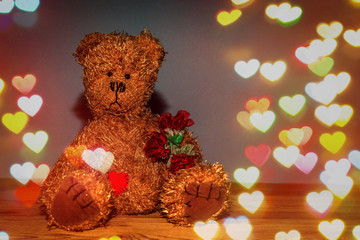Teddy Bear with flowers on wooden background.