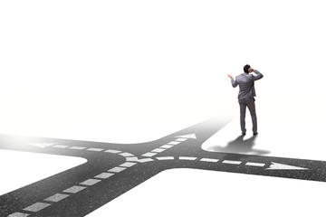 Fototapeta premium Young businessman at crossroads in uncertainty concept