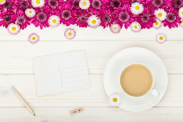 garden flowers, coffee cup and empty  postcard on white wooden rustic table background with copy space for your text. vintage card, flat lay, top view. breakfast on Mothers day or Womens day