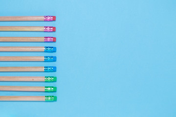 Flat lay of 9 pencils on blue background