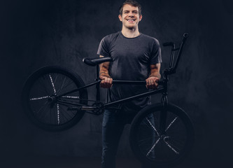 A handsome man with BMX in a studio.