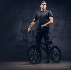 A handsome man with BMX in a studio.