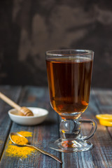 Tea, turmeric, honey and lemon on a wooden dark background