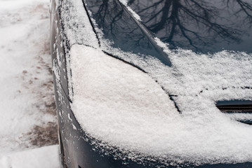 The car in the snow, covered with a white snowdrift.