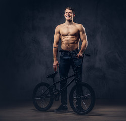 Fototapeta na wymiar A handsome man with BMX in a studio.
