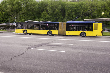Plakat yellow, urban, environmentally friendly trolleybus is moving in urban traffic