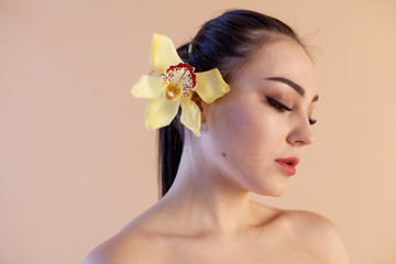 Obraz na płótnie Canvas Portrait of a girl with a flower Orchid Spa skin care
