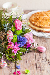 Gedeckter Ostertisch mit Frühlingsstrauß und Kuchen