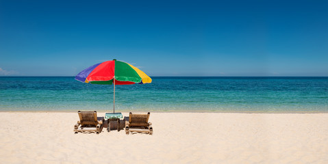 panorama with bright umbrella and beach chairs with copyspace