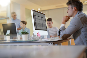 Teacher with students in apprenticeship attending computing class