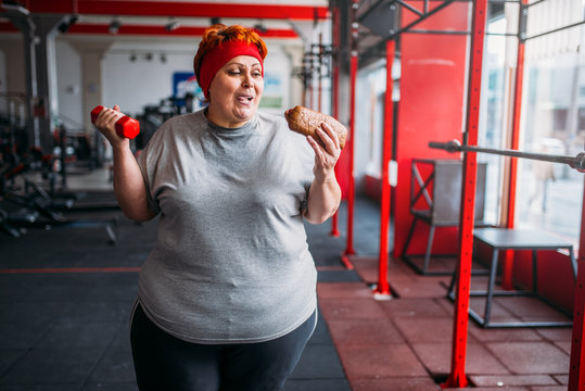 Fat woman with fast food and dumbbell, motivation