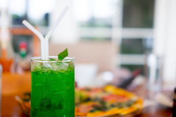 Glass with green soda aerated water