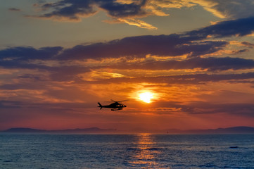 Sonnenuntergang mit Helicopter über See