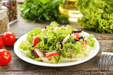 Vegetable salad in plate on wooden table