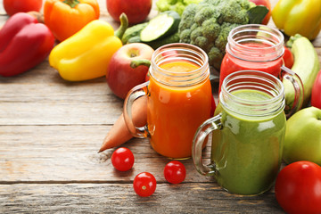 Vegetables smoothie in jars on wooden table
