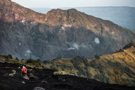 people in the neon suit is climbing the Rinjani Volcano in the morning light, Indonesia - Powered by Adobe