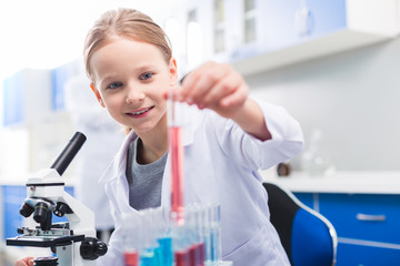 Charming pleasant girl placing vial in stand