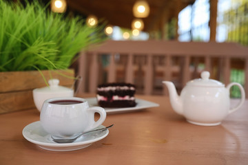 Kettle with a drink and dessert in a street cafe. Tea in the ket