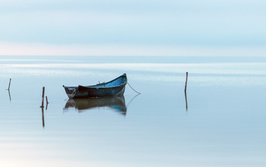 Wooden fishing boat on the lake in a misty morning	