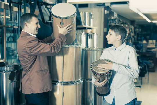 Father and teenage son examining ethnic drums