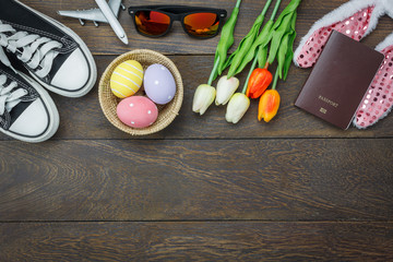 Table top view shot of decoration Happy Easter holiday background concept.Flat lay essential objects plan to travel vacation on modern brown wood at office desk.space design mock up.item to traveler.