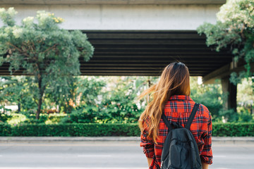 Young Asian women standing along the street enjoying her city lifestyle in a morning of a weekend waiting for outdoor activity. Young woman and her city lifestyle. city lifestyle and outdoor concept.