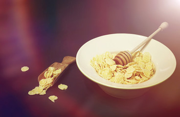 Corn flakes in a plate. Breakfast from flakes with honey and mil