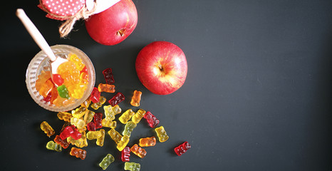 Marmalade in a vase on the table. Sweets in a bowl on a black ba