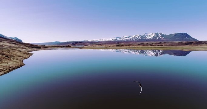 Flying over calm Iceland lake with beautiful mountains