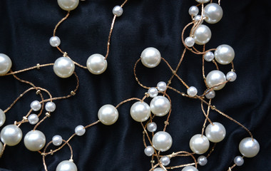 gold threads with pearls on black silk, beautiful luxury background