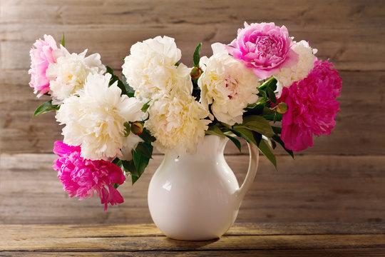 bouquet of colorful peonies flowers in a white jar