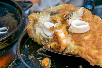 Fried seafood pancakes in hot plate, Thai style.