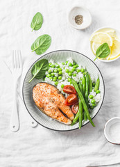 Healthy balanced meal lunch plate - baked salmon with rice and vegetables on a light background, top view.