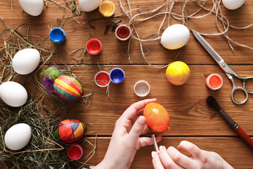 Painting colorful easter eggs, top view on wood