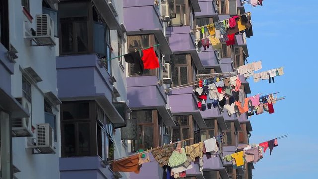 Laundry hanging to dry outside Singapore apartment building.Chinese residents hang clothes outside their windows on clothes racks for drying.