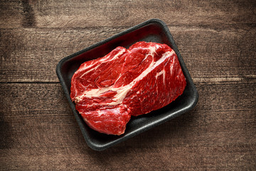 Fresh Raw braising steak on black tray