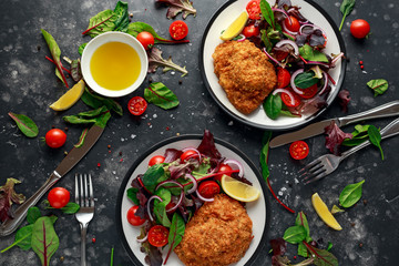 Breaded Chicken Kiev breast stuffed with butter, garlic and herbs served with vegetables in a plate.