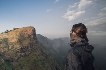Naklejka premium Handsome man Standing at the back See high peaks, steep brilliant sky spectacular views.