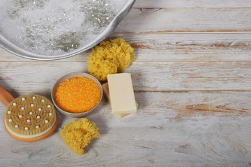 natural gray soap next to a grandmother's metal bowl with salt for a bath with a natural sponge brush and a comb with a free space for text
