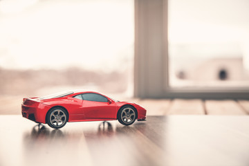 Red toy car on wood.