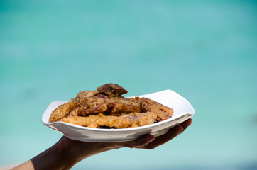 Fried banana in plate with woman hand ,seaside