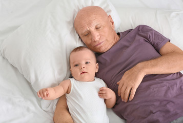 Obraz na płótnie Canvas Senior man with his little grandchild resting at home