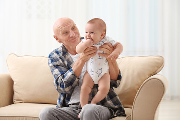 Senior man playing with his little grandchild at home