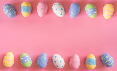 Colorful easter eggs on pink pastel color background with space.